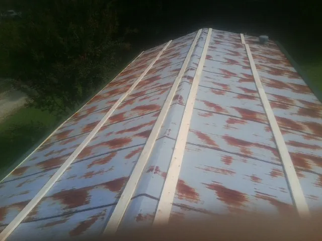 Rusted metal roof panels with new wood purlins before replacement — Storm Damage Roof Repair in Lehigh by Roofing Brothers