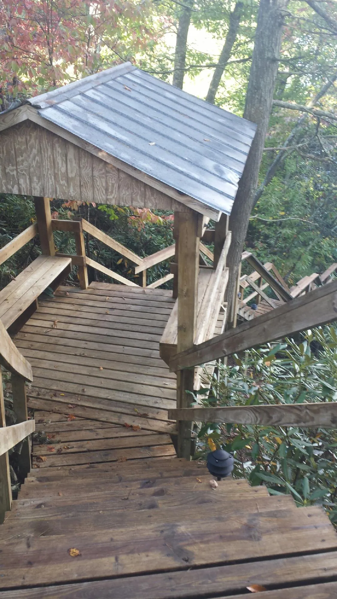 Metal roofed shelter over wooden steps on a wooded walkway — Skylight Repair & Installation work by our crew in Lehigh