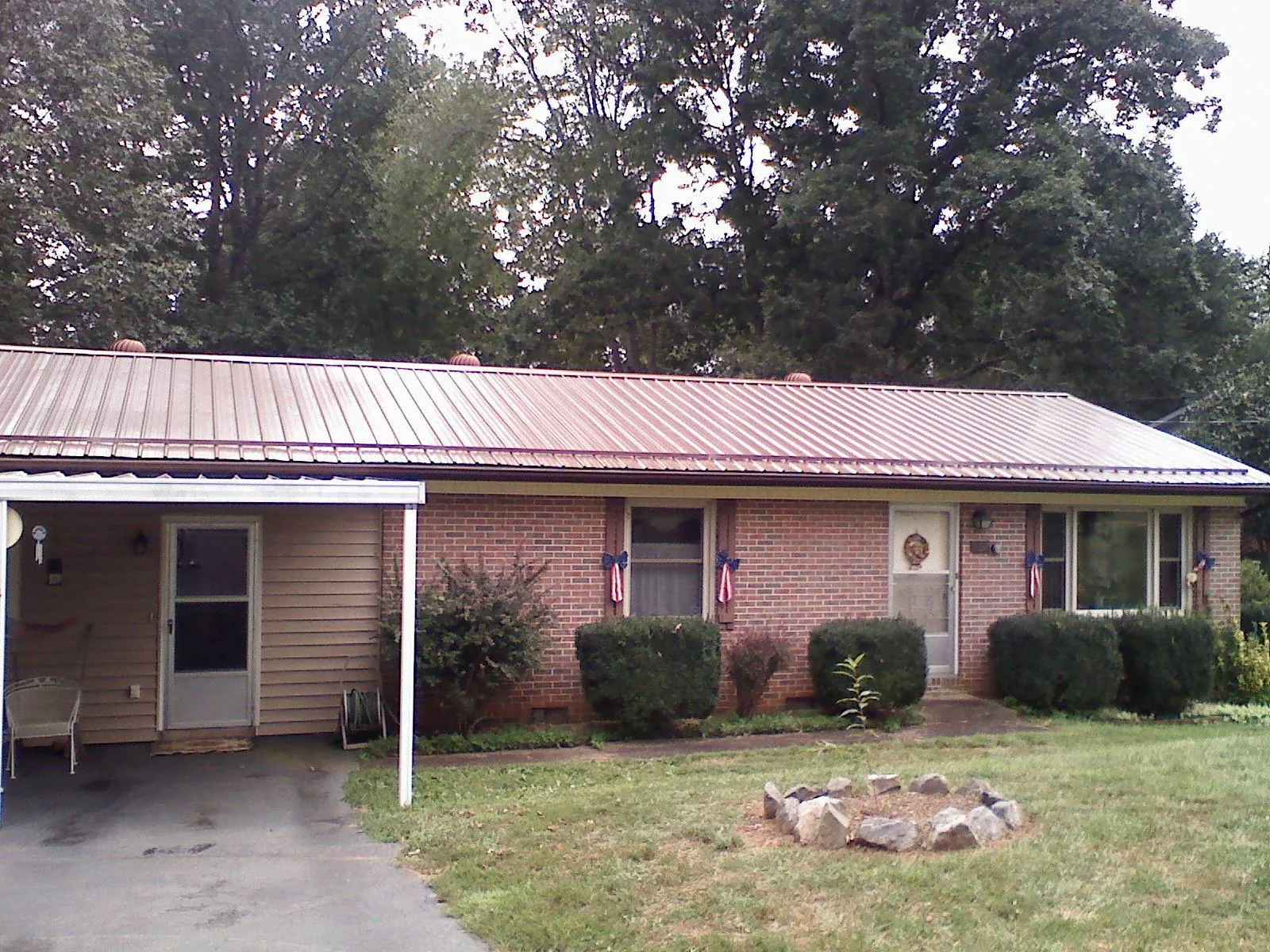Bronze metal roof and carport on a brick ranch home — Roof Repair work by our crew in Lehigh